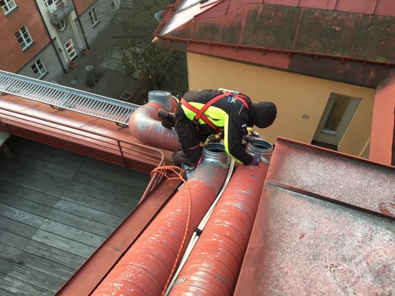 underhåll av ett stort rött plåttak